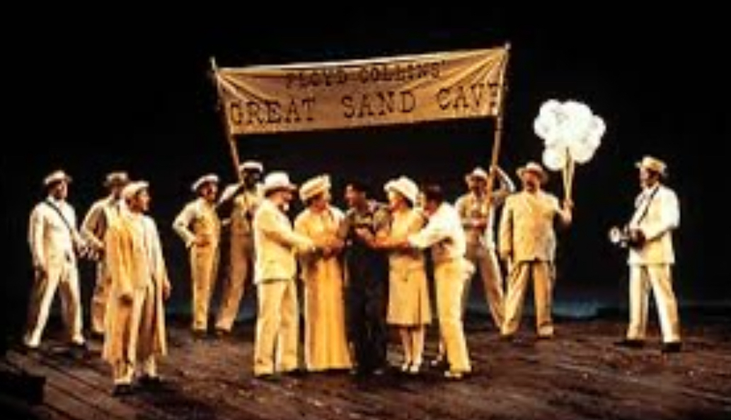A group in beige outfits holding a banner and cotton candy on stage